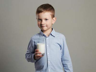 带着一杯牛奶的孩子。小男孩喜欢喝牛奶鸡尾酒。 健康的生活