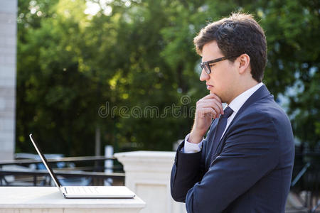 皱眉的商人看着笔记本电脑