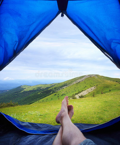 想象一下人类的腿躺在旅游帐篷里