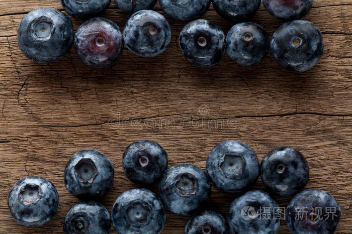 刚采摘的木制背景蓝莓。 多汁新鲜的蓝莓