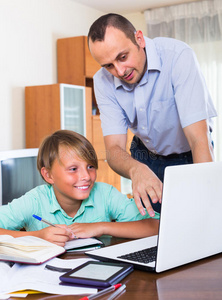 父亲帮助十几岁的儿子做家庭作业