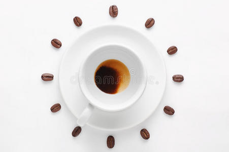 在白色背景下饮用一杯咖啡和咖啡豆，形成从顶部观看的时钟表盘