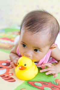 可爱的亚洲女婴玩强盗鸭玩具