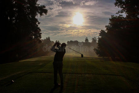 高尔夫球手在黎明的剪影