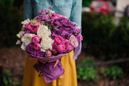 女孩拿着一束紫色和白色的花浴室里拿着花的女孩女孩与花束黄色的野花