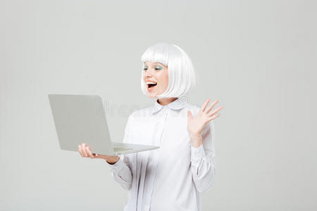 开朗可爱的年轻女人站着用笔记本电脑