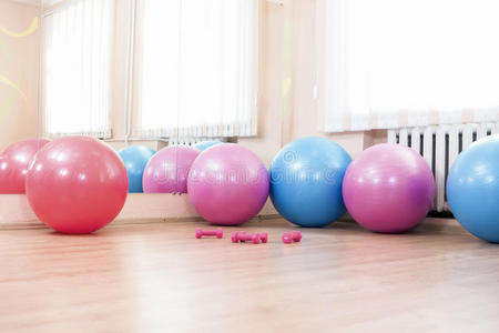 体育健身中心地板上有五个健身球和杠铃