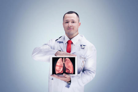 医生拿着人体器官在平板上的灰色背景。 高分辨率。