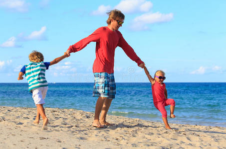 父亲和儿子和女儿在海滩玩