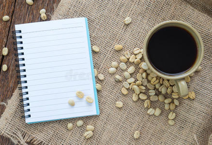 咖啡与笔记本和笔在麻布棕色。