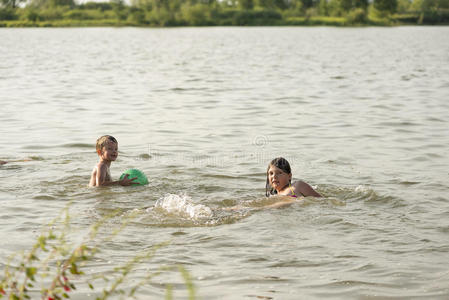 男孩和女孩在池塘里游泳