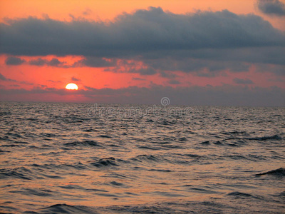 海滩日落是一片日落的天空，波浪翻滚