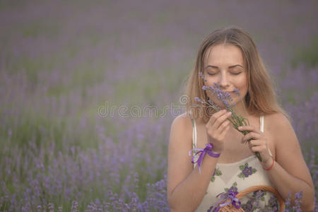 微笑的女孩在薰衣草地里嗅花
