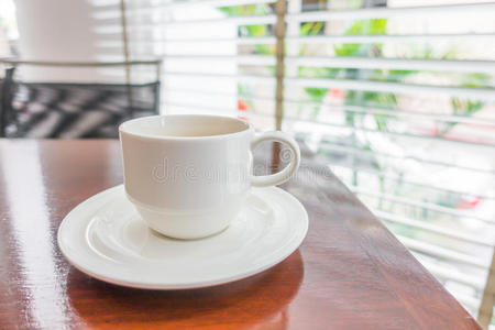 木桌上白色杯子里的咖啡。