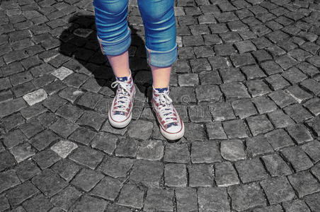 在胶鞋鞋女孩的腿在人行道上穿胶鞋照片