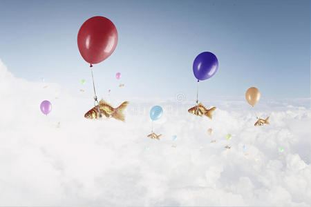 金鱼在气球上飞翔。 混合媒体
