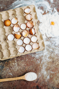 烘焙蛋糕配料碗，面粉，鸡蛋，蛋清泡沫，鸡蛋在木黑板上从上面。 烹饪课程或厨房M
