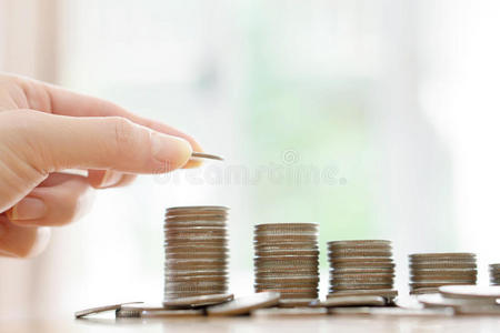 一个省钱的概念，男性的手放钱硬币堆叠增长