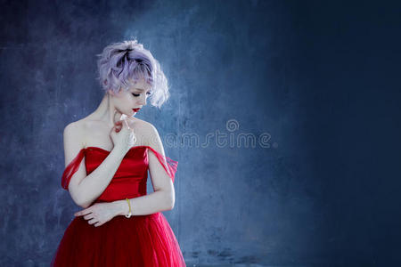 穿着红色连衣裙的年轻漂亮女人的时尚照片。纹理背景