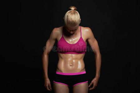 运动女孩。 健身房的概念。 肌肉健康的女人，训练有素的女性身体，健康的生活方式