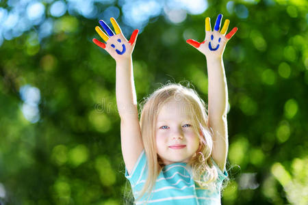 可爱的小女孩，她的手画在户外玩得很开心