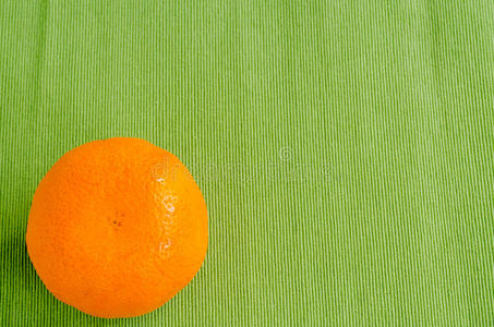 绿色桌布背景上的新鲜橙色
