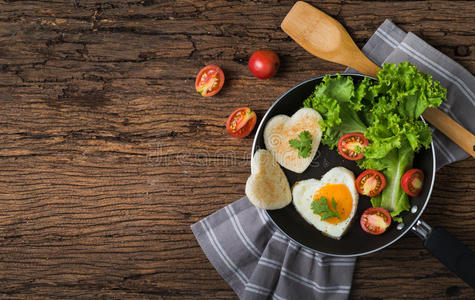 煎鸡蛋和面包的形状是心脏和新鲜蔬菜