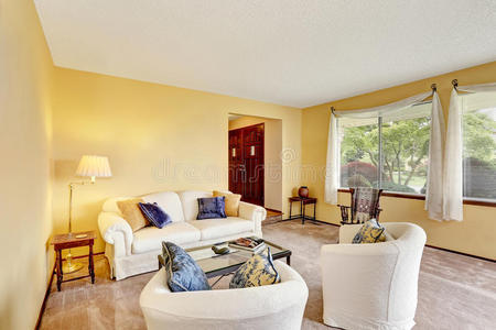 舒适的客厅，浅黄色的墙壁和白色的家具