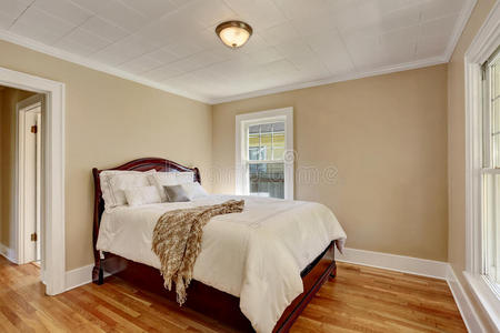 空卧室内部有白色床上用品和硬木地板。
