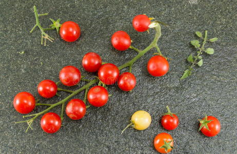 樱桃番茄和红辣椒在石头背景上照片