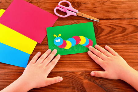 儿童纸贴花彩色毛毛虫在绿色薄板。儿童夏季工艺品