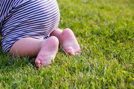 关门。 快乐的孩子赤脚在绿色的草地上。 健康的生活方式。 春天的时候。 后视镜。 平脚的概念