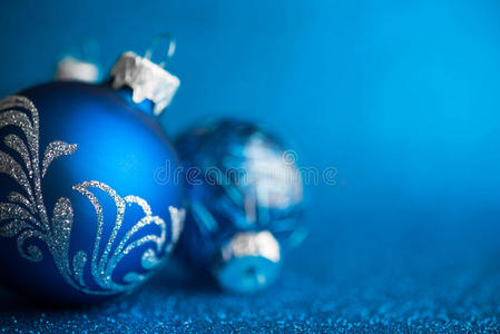 深蓝色闪光背景上的蓝色圣诞装饰品