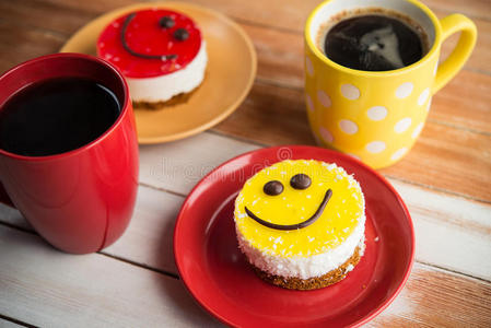 咖啡红杯和木桌上的微笑蛋糕