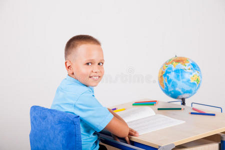 男孩坐在书桌前做作业