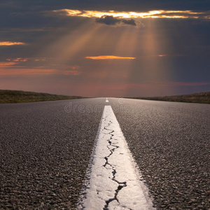 开车在空旷的道路上朝夕阳行驶照片