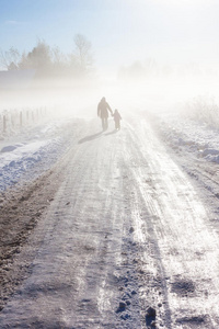 雾蒙蒙的雪路上的母子俩