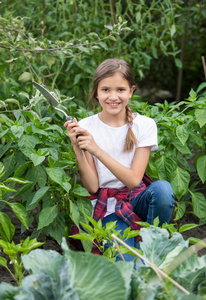 美丽微笑的十几岁女孩在花园工作