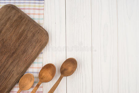 剪板和勺子在厨房餐巾上的旧木桌上。