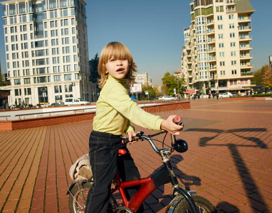 男孩骑自行车在城里