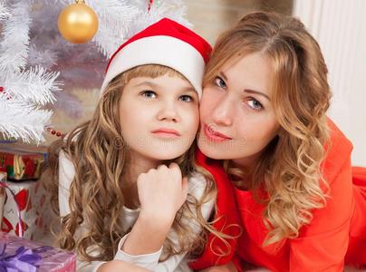 艾莉莎和亚历山德拉。 圣诞女孩和母亲红帽和树