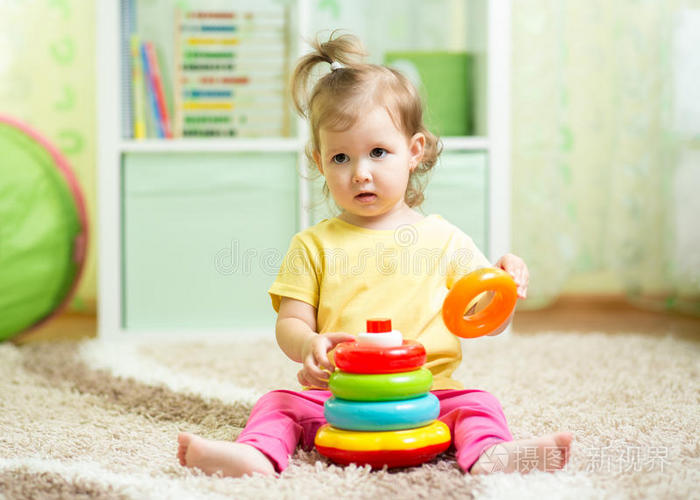 可爱的婴儿在家里玩五颜六色的玩具