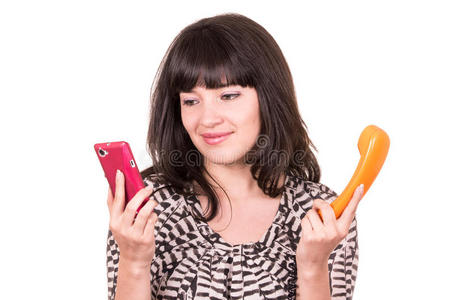 美丽的年轻女人使用复古橙色和手机电话