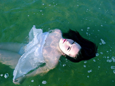 水中激情穿着衣服的漂亮女人漂浮在水中照片