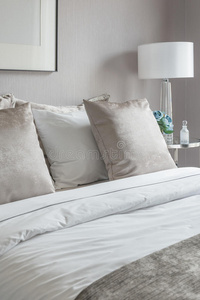 经典的卧室风格，床上有一套枕头和白色的灯