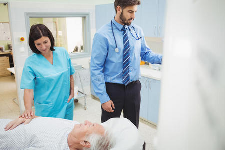 当医生和技术人员观看时，病人被装入MRI机器