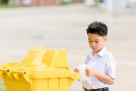 生态保护的概念男孩扔垃圾小孩捡垃圾和放在黑色的垃圾袋里自然的背景