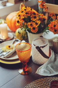 秋季传统的季节性餐桌，在家里摆放南瓜蜡烛和鲜花