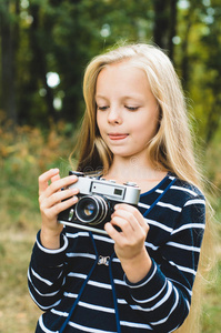 可爱的小女孩带着老式的测距仪相机。