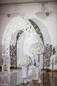 美丽的婚礼设计装饰元素与拱门，花卉，花，椅子室内
